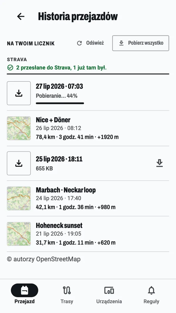 Historia jazd: jazda pobierana z licznika w 44 %, informacja, że dwie jazdy trafiły do Stravy, a jedna już tam była, oraz jazdy już w telefonie, każda z małą mapką przejechanej trasy.